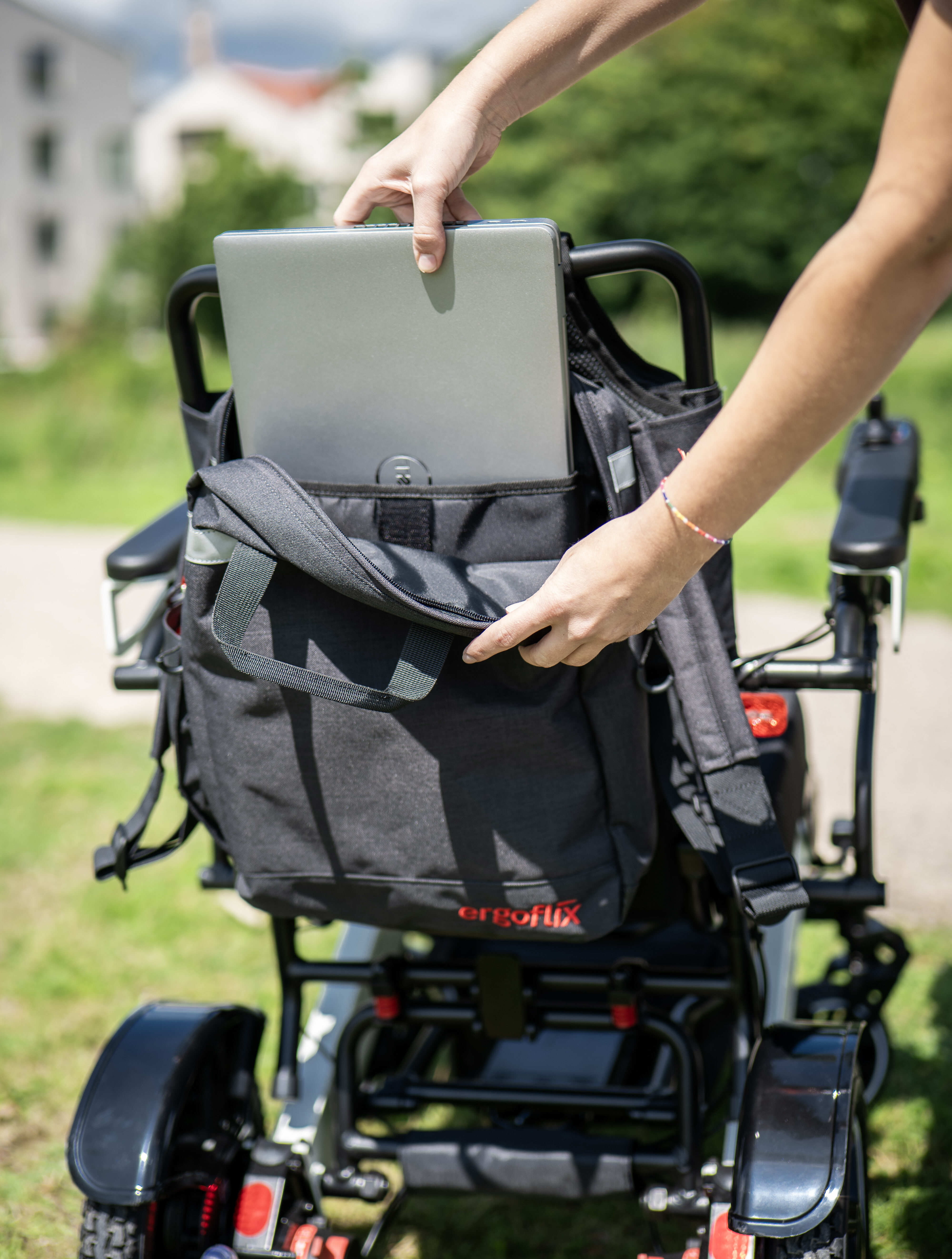 Das Foto zeigt einen ergoflix-Rollstuhl von hinten, an dem der Rollstuhlrucksack von ergoflix angebracht ist.